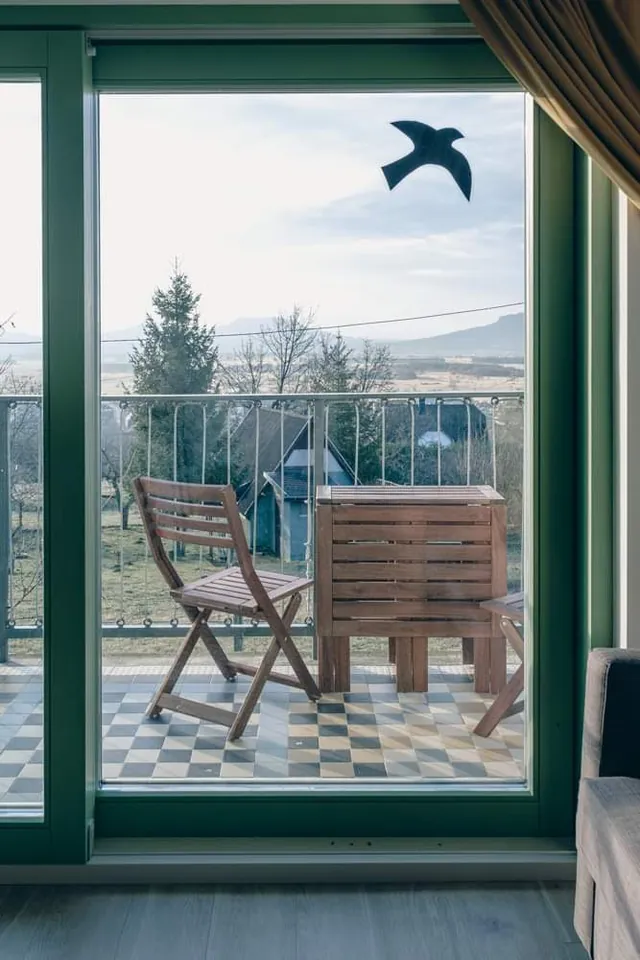 Kilátás a teraszajtón át a székekre és a medencére
